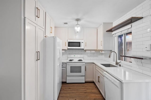 kitchen featuring tasteful backsplash, white cabinetry, sink, and white appliances