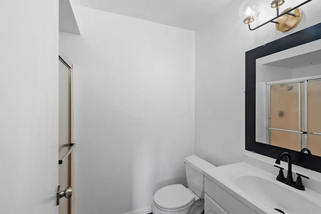 bathroom with vanity, toilet, and an enclosed shower