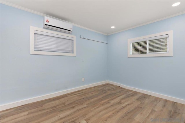 unfurnished room with ornamental molding, a wall mounted air conditioner, and hardwood / wood-style floors