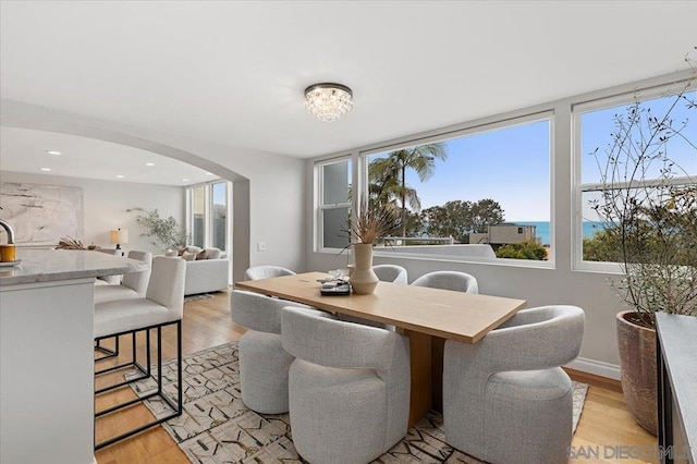 dining space with a water view and light wood-type flooring