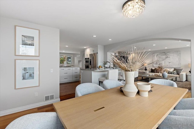 dining area featuring hardwood / wood-style flooring and a chandelier