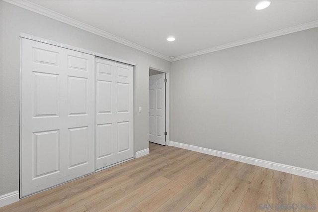 unfurnished bedroom featuring ornamental molding, a closet, and light hardwood / wood-style flooring