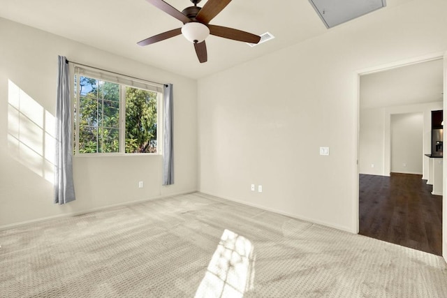 spare room featuring light colored carpet and ceiling fan