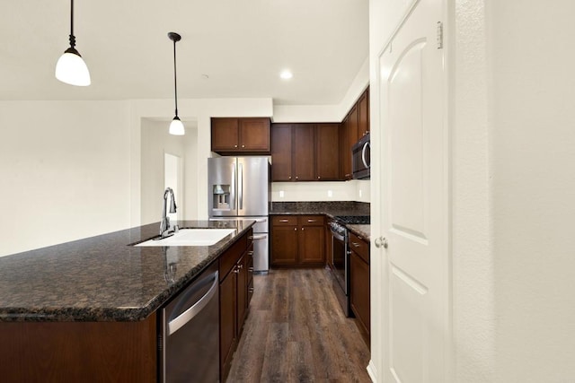 kitchen featuring sink, dark hardwood / wood-style floors, an island with sink, pendant lighting, and stainless steel appliances