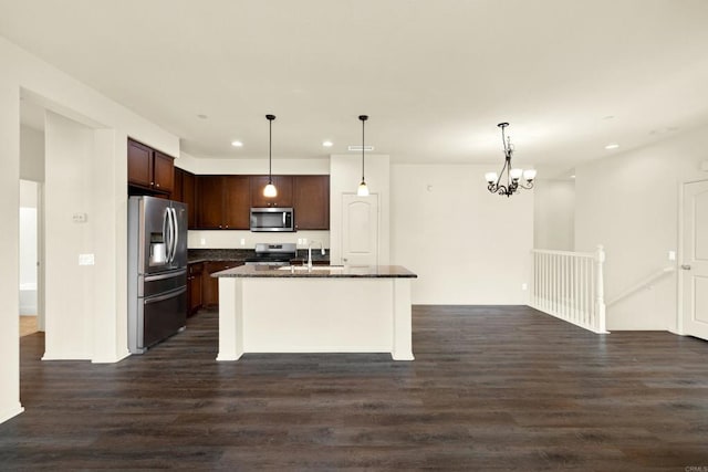 kitchen with pendant lighting, sink, appliances with stainless steel finishes, dark hardwood / wood-style floors, and an island with sink