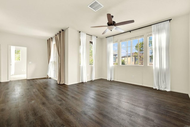 spare room featuring ceiling fan, plenty of natural light, and dark hardwood / wood-style floors