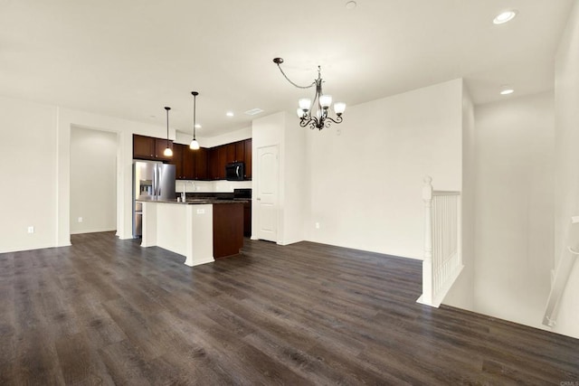 kitchen featuring appliances with stainless steel finishes, dark hardwood / wood-style floors, pendant lighting, an island with sink, and a chandelier