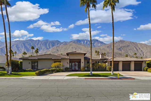 mediterranean / spanish-style home with a garage and a mountain view