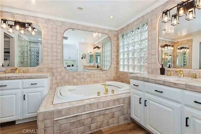 bathroom with crown molding, wood-type flooring, tile walls, and vanity