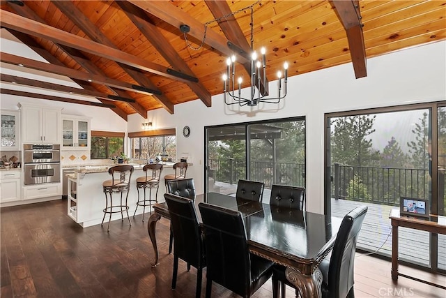 dining area featuring dark wood-type flooring, a notable chandelier, wooden ceiling, and vaulted ceiling with beams