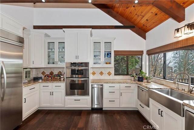 kitchen with sink, light stone countertops, white cabinets, and appliances with stainless steel finishes