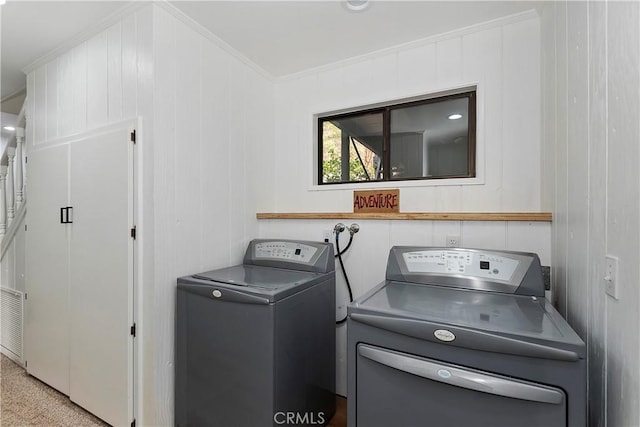 clothes washing area featuring crown molding and washing machine and dryer