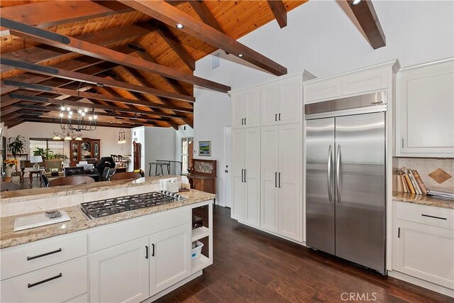 kitchen featuring appliances with stainless steel finishes, vaulted ceiling with beams, white cabinets, and dark hardwood / wood-style flooring