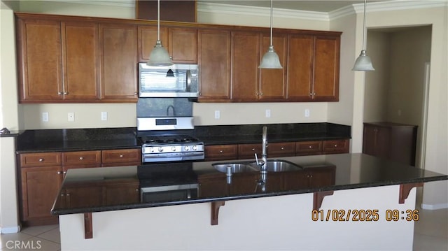 kitchen featuring pendant lighting, stainless steel appliances, sink, and a breakfast bar area