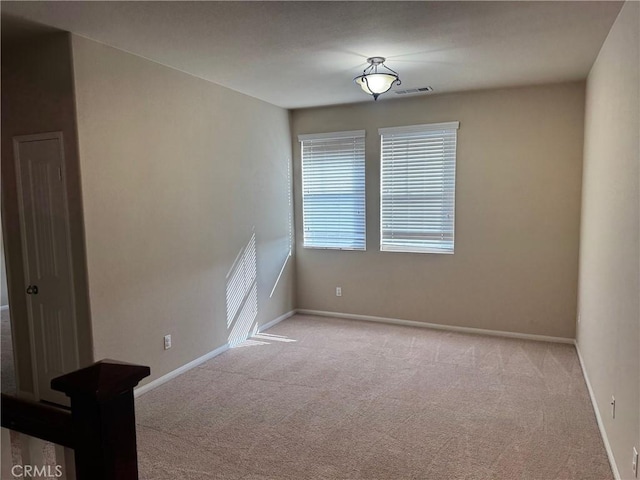 spare room featuring light colored carpet