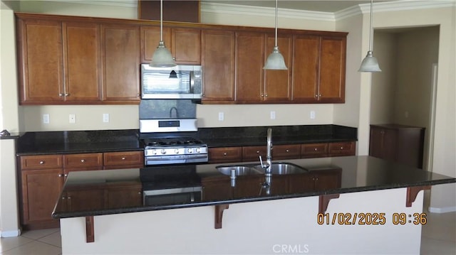 kitchen with pendant lighting, appliances with stainless steel finishes, a kitchen bar, and sink