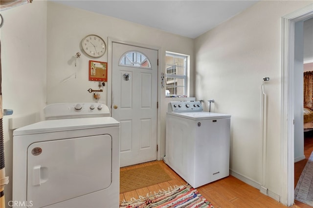 laundry room featuring washer and dryer and light hardwood / wood-style flooring