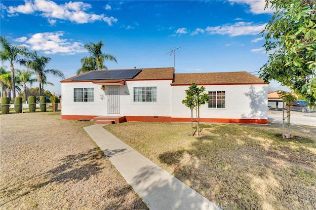 view of front of home featuring a front lawn and solar panels