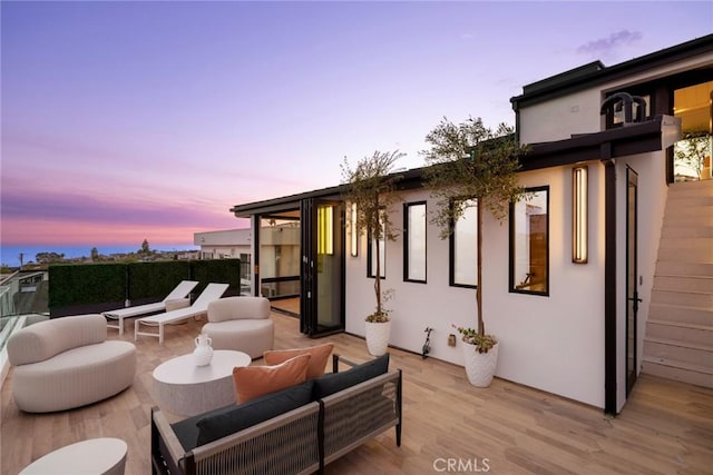 patio terrace at dusk featuring an outdoor hangout area