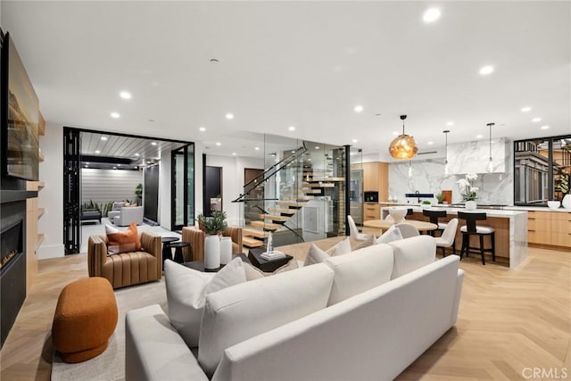 living room with a large fireplace and light parquet flooring