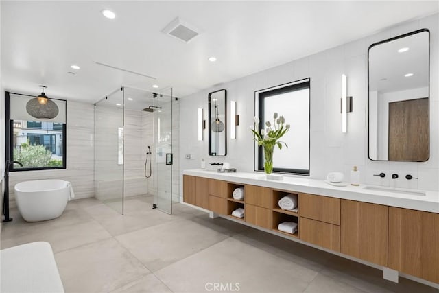 bathroom featuring tile patterned flooring, vanity, shower with separate bathtub, and tile walls