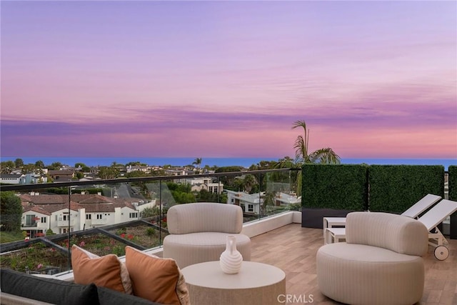 patio terrace at dusk featuring a balcony