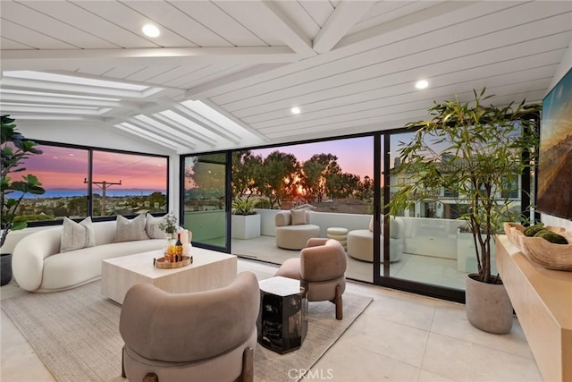 sunroom featuring a healthy amount of sunlight and vaulted ceiling with beams