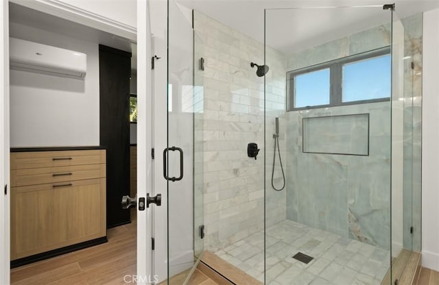 full bathroom featuring a shower stall, a wall unit AC, and wood finished floors