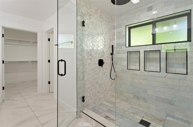 bathroom with baseboards, marble finish floor, and a stall shower