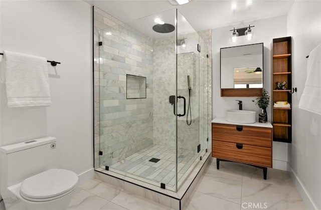 bathroom featuring baseboards, toilet, a shower stall, vanity, and marble finish floor
