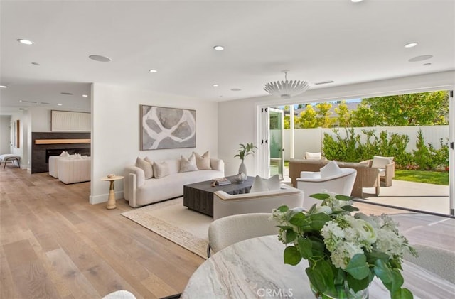 living area with light wood-type flooring, baseboards, and recessed lighting