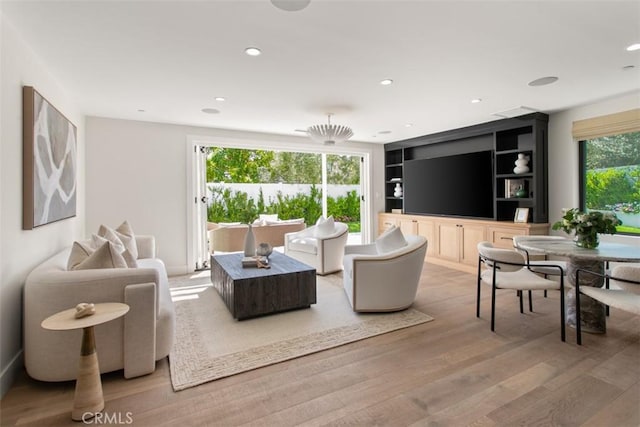 living area featuring built in shelves, recessed lighting, and wood finished floors
