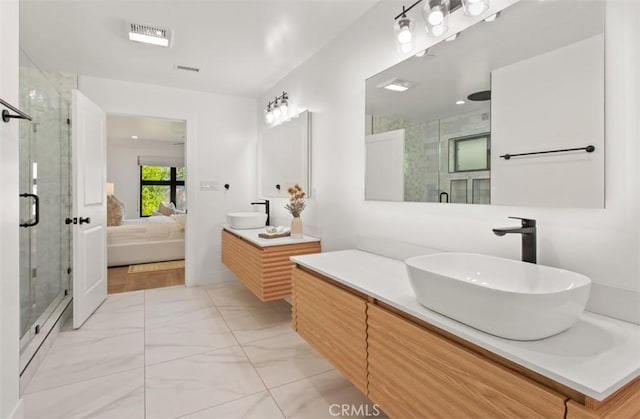 ensuite bathroom with a sink, visible vents, a shower stall, and marble finish floor