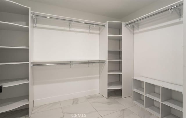 spacious closet featuring marble finish floor