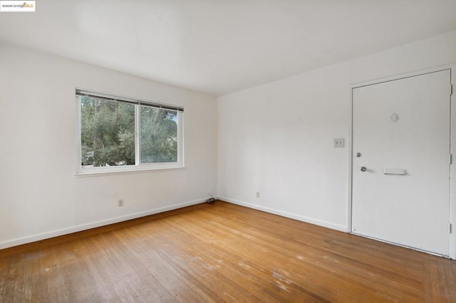 empty room with hardwood / wood-style flooring