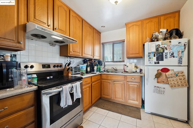 kitchen with sink, tasteful backsplash, light tile patterned floors, white refrigerator, and stainless steel electric stove