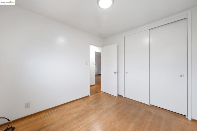 unfurnished bedroom featuring a closet and light hardwood / wood-style flooring