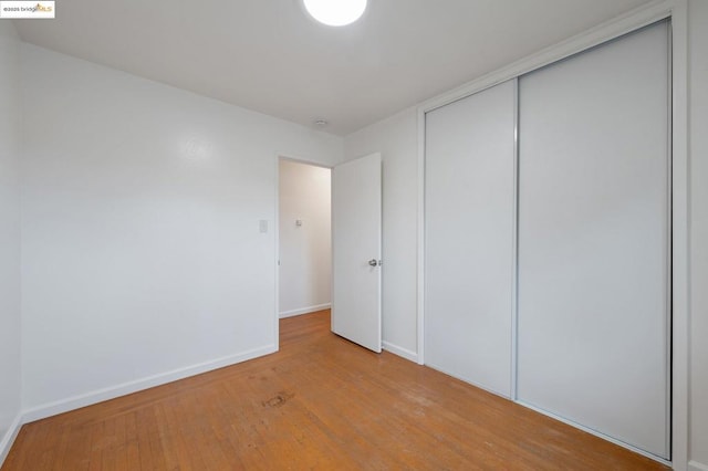 unfurnished bedroom featuring hardwood / wood-style floors and a closet