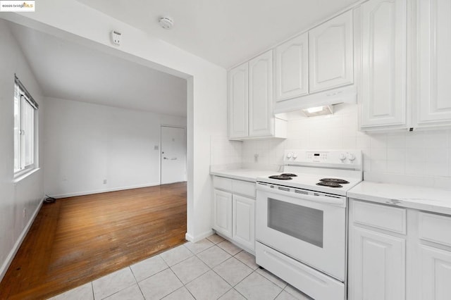 kitchen with white cabinetry, light tile patterned floors, electric range, and backsplash