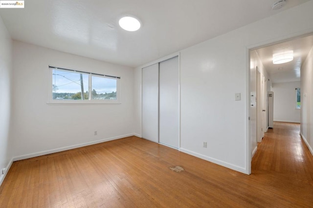 unfurnished bedroom with hardwood / wood-style flooring and a closet