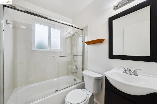 full bathroom with bath / shower combo with glass door, vanity, and toilet