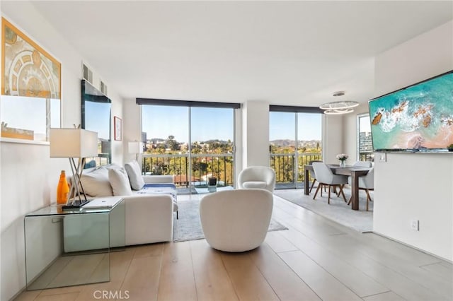 living room featuring light hardwood / wood-style flooring and a wall of windows