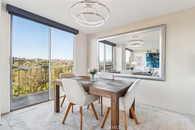 dining room with an inviting chandelier and a wall of windows