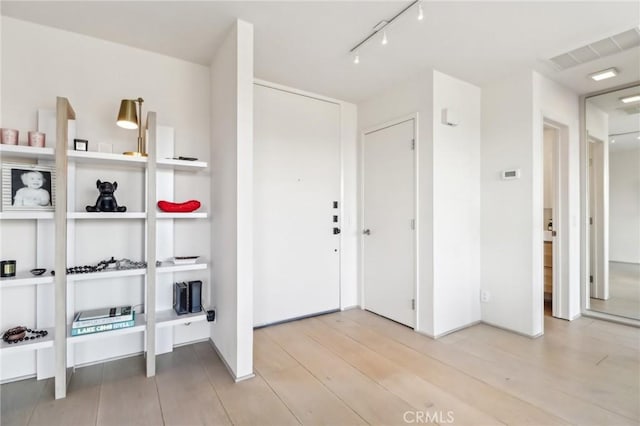 entrance foyer featuring rail lighting and light hardwood / wood-style flooring