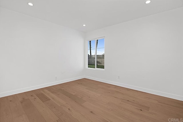 spare room with light wood-style floors, recessed lighting, and baseboards