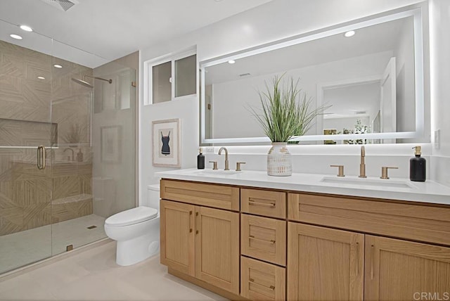 bathroom with toilet, a shower stall, double vanity, and a sink