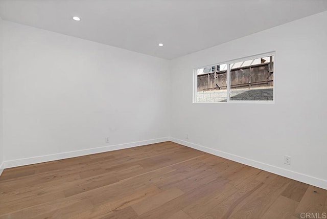 empty room featuring baseboards, wood finished floors, and recessed lighting