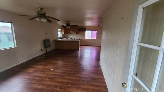 unfurnished living room featuring heating unit and dark hardwood / wood-style floors