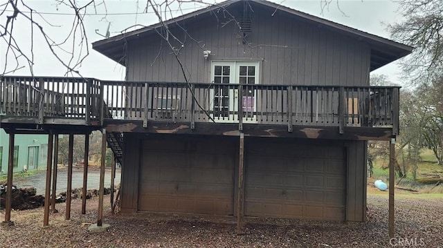 rear view of property with a garage and a deck