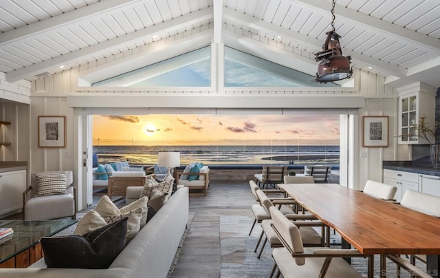 dining space with dark hardwood / wood-style flooring and vaulted ceiling with beams